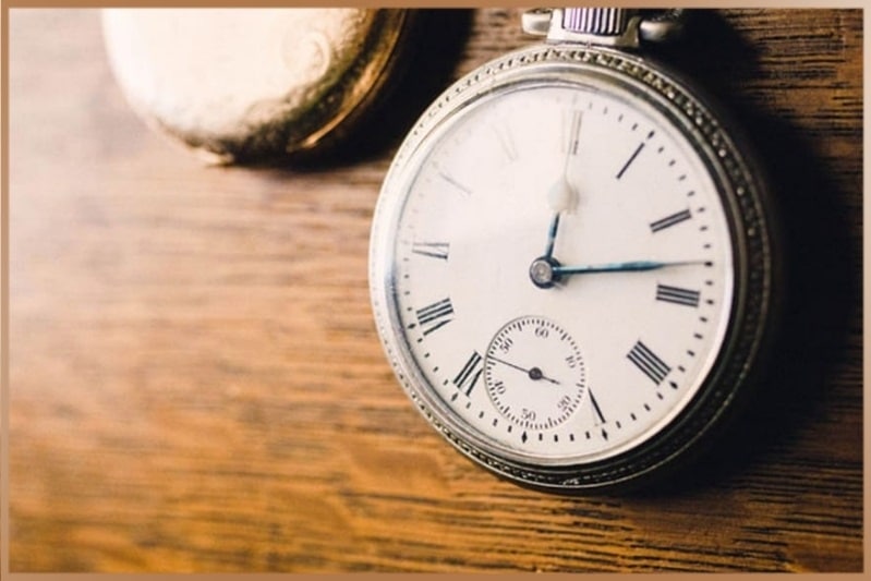 Old clock on wooden table